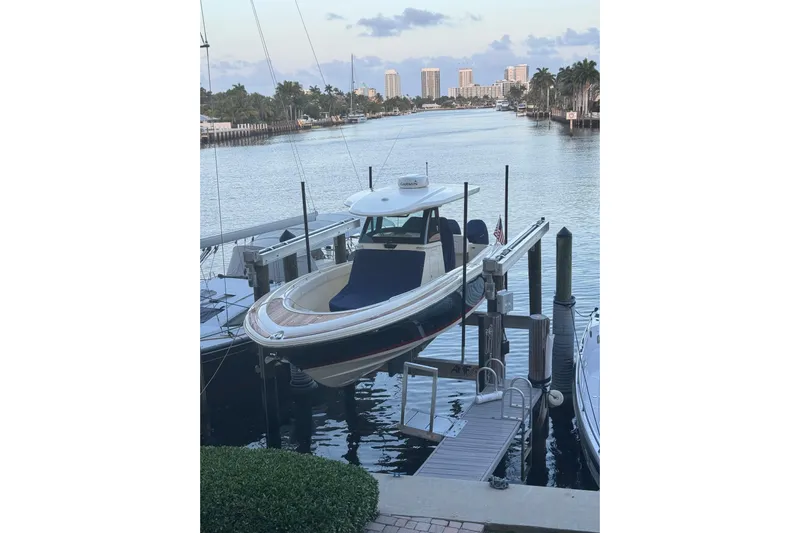 Para-dice Yacht Photos Pics 2023 Chris-Craft Catalina 30 docked by a scenic waterfront with palm trees.
