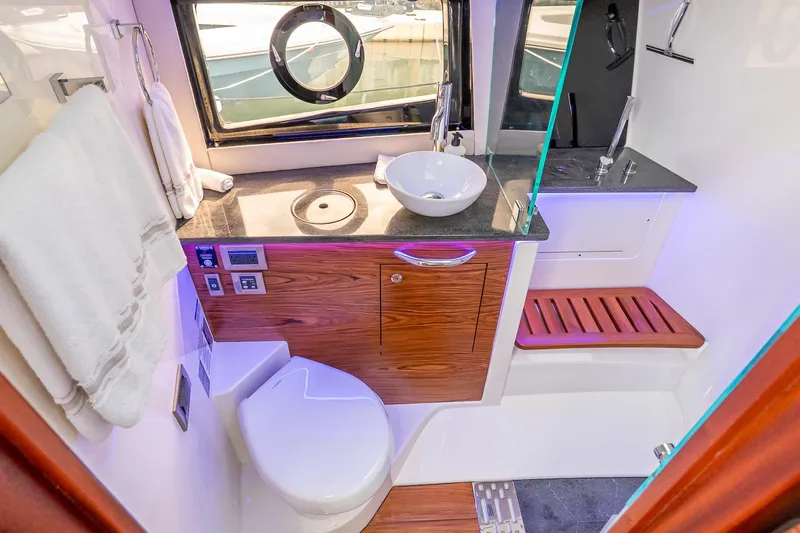 Yacht Photos Pics Luxurious bathroom interior of 2024 Boston Whaler 405 Conquest yacht, featuring modern fixtures and wood accents.