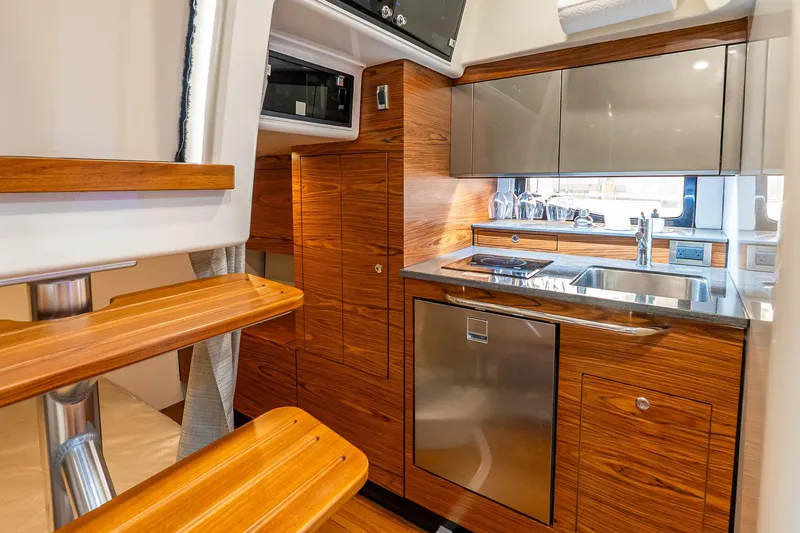  Yacht Photos Pics 2024 Boston Whaler 405 Conquest interior kitchen with wood finish and modern appliances.