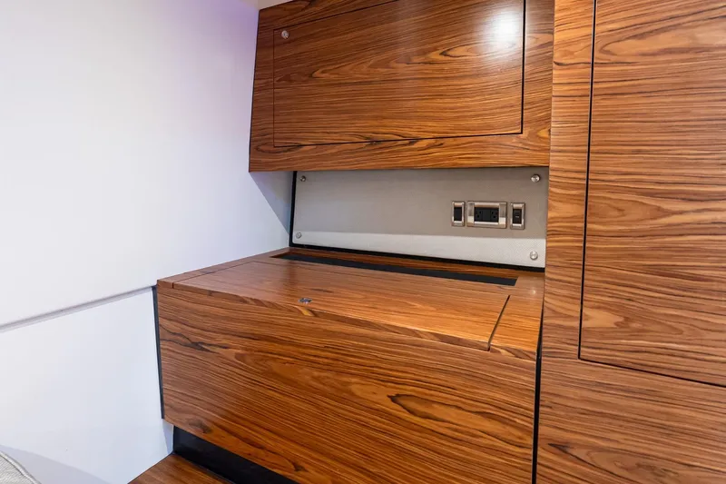  Yacht Photos Pics 2024 Boston Whaler 405 Conquest interior with sleek wooden cabinetry and modern electrical outlets.