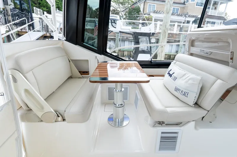  Yacht Photos Pics 2024 Boston Whaler 405 Conquest interior with plush seating and wooden table.