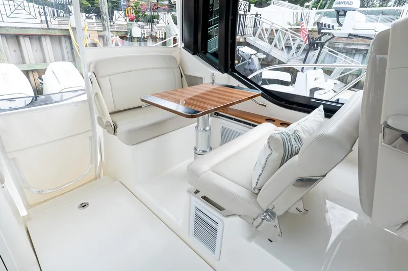  Yacht Photos Pics 2024 Boston Whaler 405 Conquest interior with seating and wooden table.