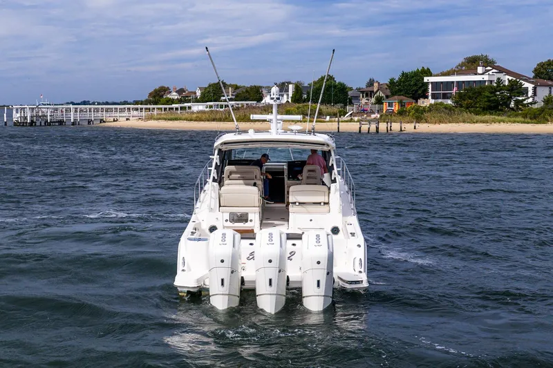  Yacht Photos Pics 2024 Boston Whaler 405 Conquest cruising near a scenic shoreline.
