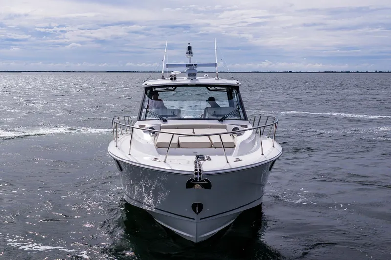  Yacht Photos Pics 2024 Boston Whaler 405 Conquest cruising on open water under a cloudy sky.
