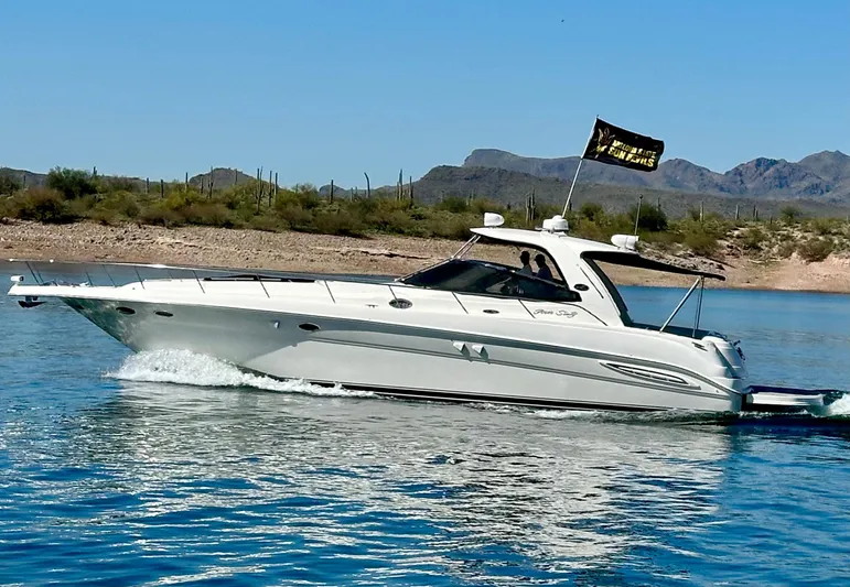 Notorious Yacht Photos Pics 2003 Sea Ray 460 Sundancer cruising on a lake with mountainous backdrop.