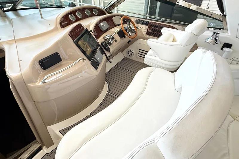 Notorious Yacht Photos Pics 2003 Sea Ray 460 Sundancer helm with luxurious white seating and advanced navigation controls.