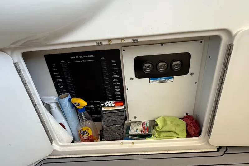 Notorious Yacht Photos Pics Storage compartment on a 2003 Sea Ray 460 Sundancer with cleaning supplies and control panel.