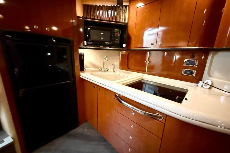 Notorious Yacht Photos Pics Luxurious kitchen interior of 2003 Sea Ray 460 Sundancer yacht with wood cabinetry.