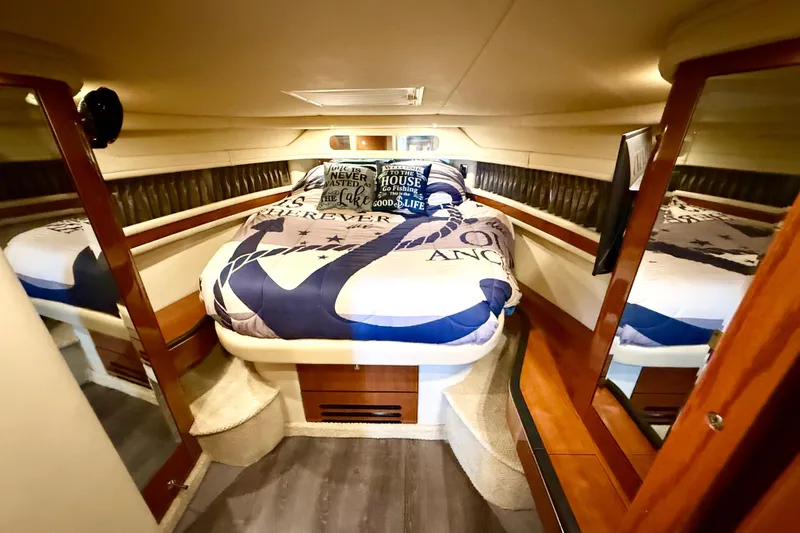 Notorious Yacht Photos Pics Luxurious 2003 Sea Ray 460 Sundancer cabin with nautical-themed bedding and mirrored walls.