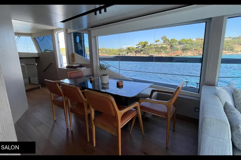  Yacht Photos Pics Luxurious 2023 Numarine 22 XP yacht salon with elegant dining area and scenic ocean view.