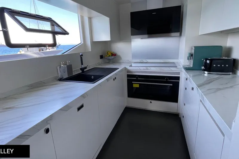  Yacht Photos Pics Modern galley kitchen on 2023 Numarine 22 XP yacht with sleek appliances and ocean view.