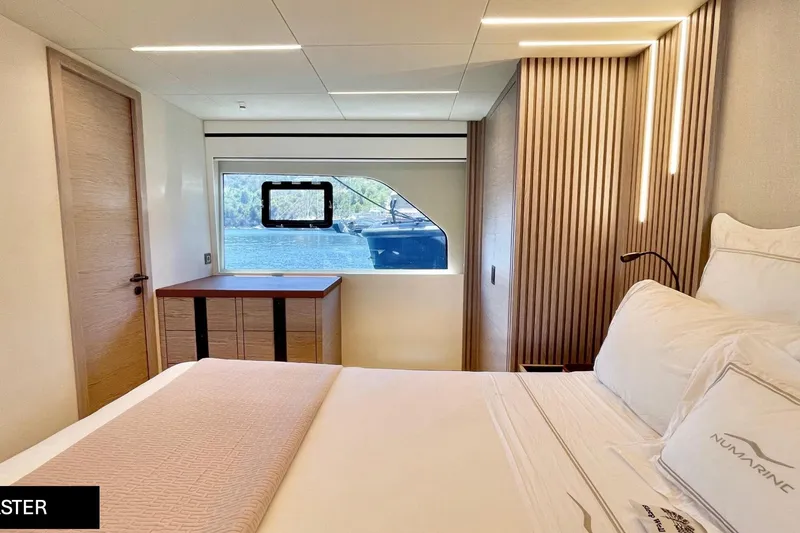  Yacht Photos Pics Luxurious bedroom interior of 2023 Numarine 22 XP yacht with modern design and scenic window view.