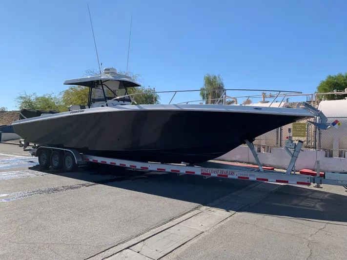 Shaka Yacht Photos Pics 2002 Fountain 38 CC Tournament Edition boat on trailer, parked outdoors.