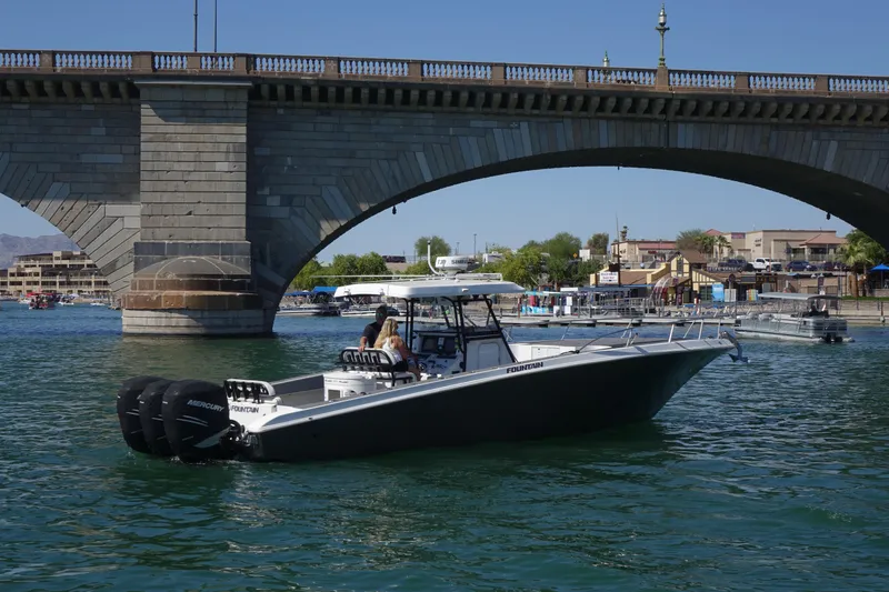 Shaka Yacht Photos Pics 2002 Fountain 38 CC Tournament Edition boat cruising under a bridge on a sunny day.