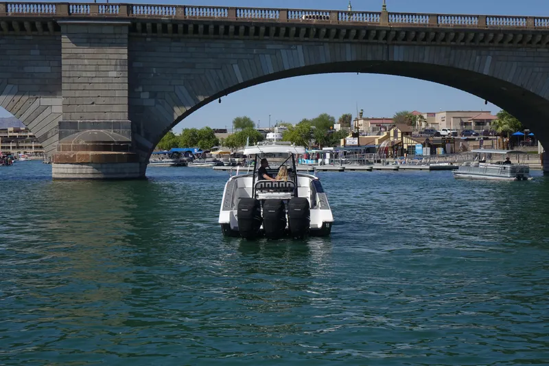 Shaka Yacht Photos Pics 2002 Fountain 38 CC Tournament Edition boat under a bridge on a sunny day.