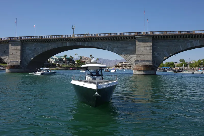 Shaka Yacht Photos Pics 2002 Fountain 38 CC Tournament Edition boat on water near a stone bridge.
