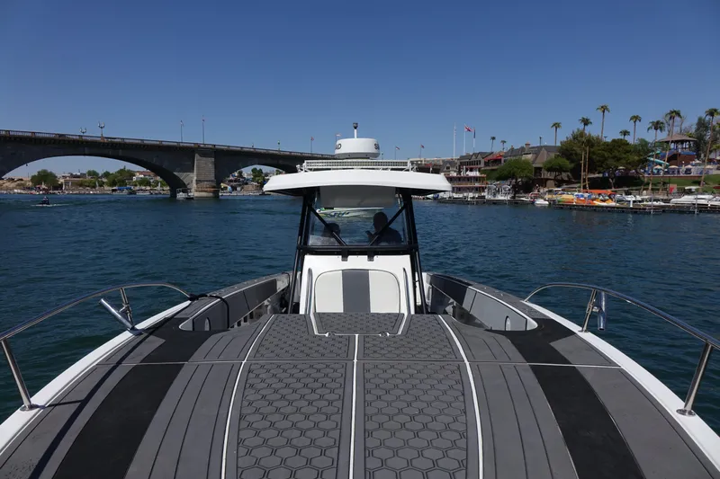 Shaka Yacht Photos Pics 2002 Fountain 38 CC Tournament Edition boat on water near a bridge and shoreline.