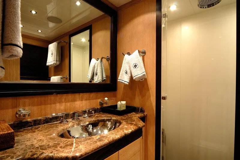 Ares Yacht Photos Pics Luxurious bathroom in 2005 Mangusta 108 yacht with marble countertop and elegant fixtures.