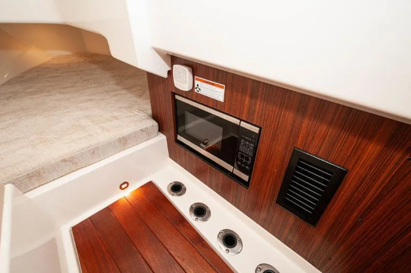 Silver Lining Yacht Photos Pics 2023 Pursuit DC 365 Dual Console interior with wood paneling and built-in microwave.