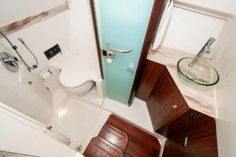 Silver Lining Yacht Photos Pics 2023 Pursuit DC 365 Dual Console bathroom with modern fixtures and wood accents.