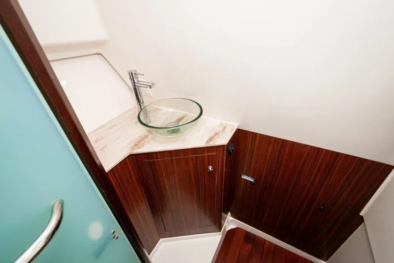 Silver Lining Yacht Photos Pics 2023 Pursuit DC 365 Dual Console bathroom with modern sink and wood accents.