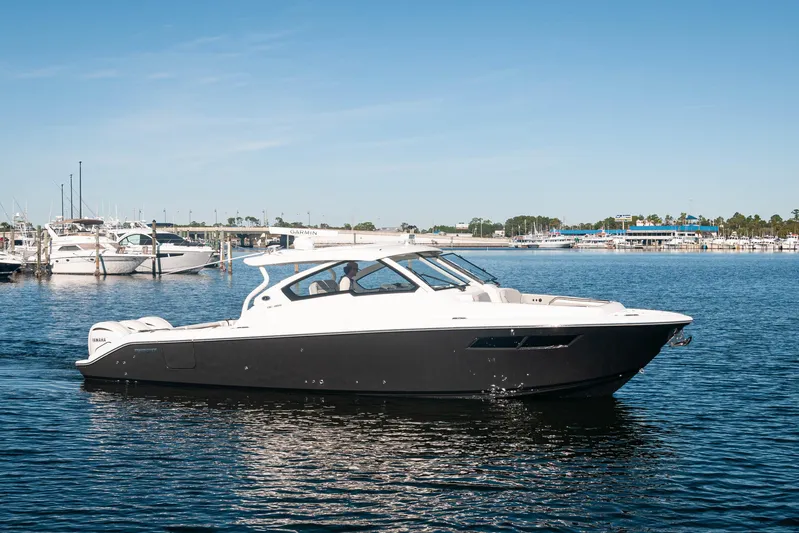 Silver Lining Yacht Photos Pics 2023 Pursuit DC 365 Dual Console boat on calm water near a marina.