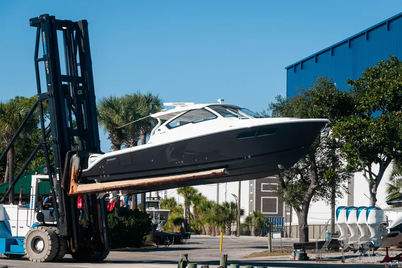 Silver Lining Yacht Photos Pics 2023 Pursuit DC 365 Dual Console boat lifted by forklift near marina.