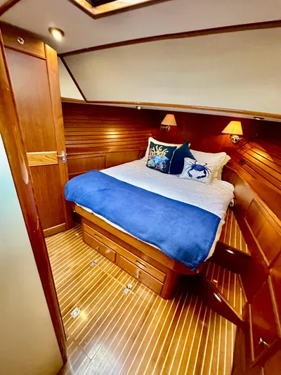 Moonshadow Yacht Photos Pics Luxurious cabin interior of 2004 Grand Banks 49 Eastbay HX with cozy bedding and wooden finish.