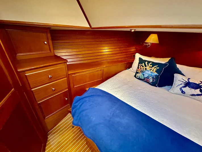 Moonshadow Yacht Photos Pics Luxurious cabin interior of 2004 Grand Banks 49 Eastbay HX with cozy bedding and wooden cabinetry.