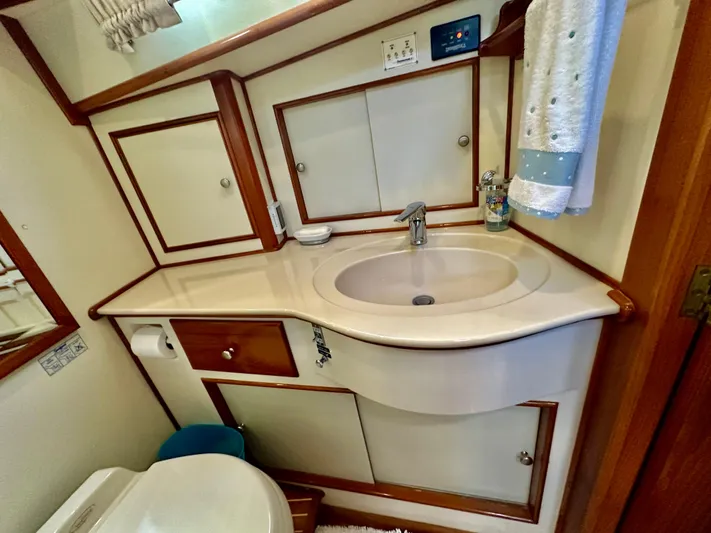 Moonshadow Yacht Photos Pics 2004 Grand Banks 49 Eastbay HX bathroom with sink, mirror, and storage cabinets.