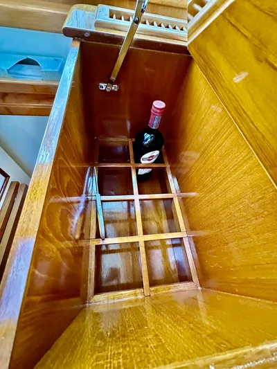 Moonshadow Yacht Photos Pics Wooden storage compartment with a bottle, inside a 2004 Grand Banks 49 Eastbay HX yacht.