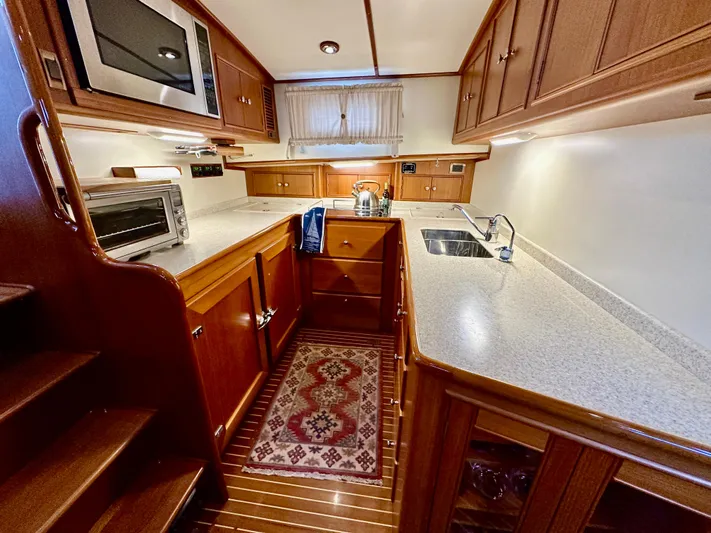 Moonshadow Yacht Photos Pics Luxurious 2004 Grand Banks 49 Eastbay HX yacht kitchen with wood cabinetry and modern appliances.