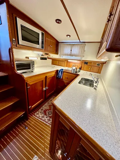 Moonshadow Yacht Photos Pics 2004 Grand Banks 49 Eastbay HX yacht kitchen with modern appliances and wooden cabinetry.