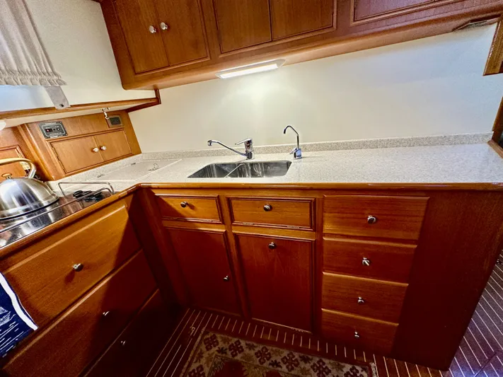 Moonshadow Yacht Photos Pics 2004 Grand Banks 49 Eastbay HX galley with wooden cabinetry and stainless steel sink.