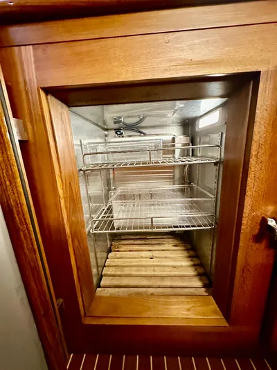 Moonshadow Yacht Photos Pics Wooden cabinet with glass door and metal shelves on a 2004 Grand Banks 49 Eastbay HX.