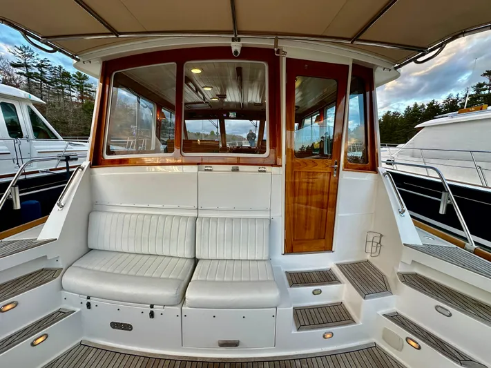 Moonshadow Yacht Photos Pics 2004 Grand Banks 49 Eastbay HX yacht with cushioned seating and wooden door.