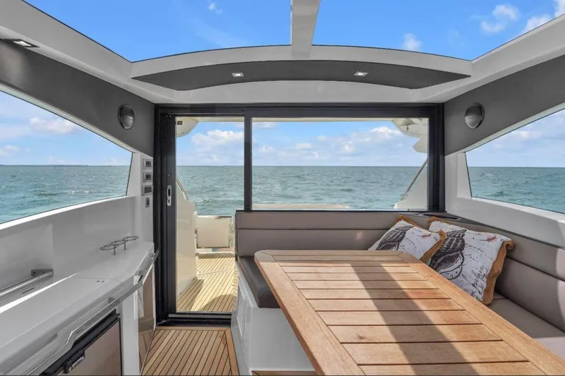 Empire Yacht Photos Pics Interior of 2017 Galeon 445 HTS yacht with ocean view and wooden table.
