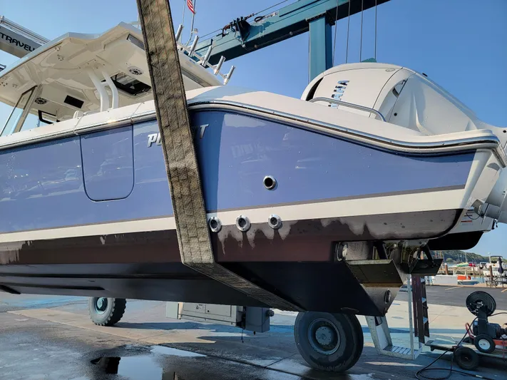 Over Bohr’d Yacht Photos Pics 2023 Pursuit S 328 Sport boat being lifted at a marina.