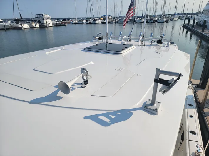 Over Bohr’d Yacht Photos Pics 2023 Pursuit S 328 Sport boat docked at marina with American flag.