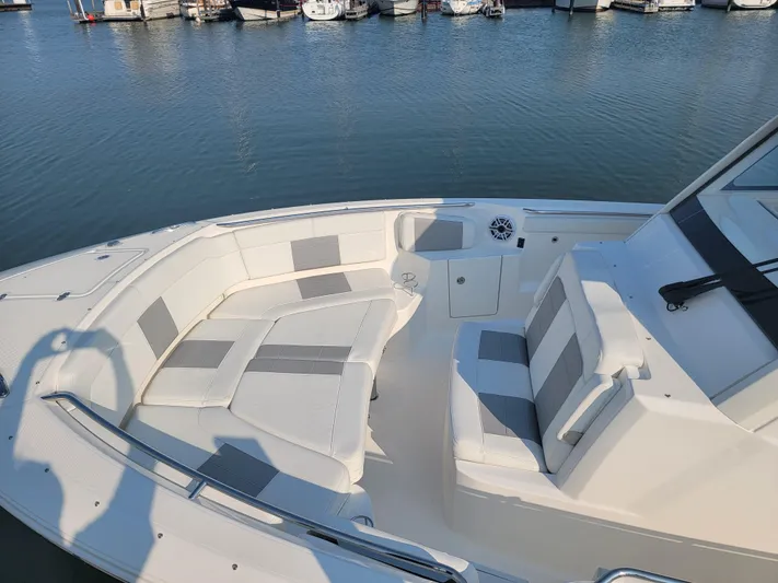 Over Bohr’d Yacht Photos Pics 2023 Pursuit S 328 Sport boat with spacious seating, docked at marina.