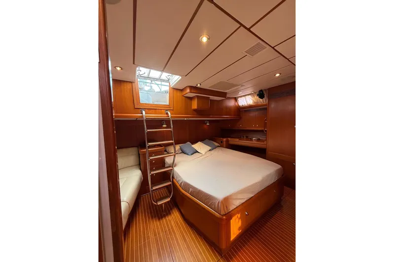 4961 Yacht Photos Pics Luxurious cabin interior of 2000 Nautor Swan 60 yacht with wooden finish and cozy bed.