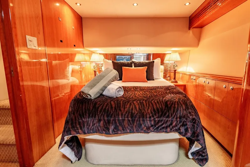 Reel Ranchin Yacht Photos Pics Luxurious bedroom interior of 2004 Hatteras 54 Convertible yacht with elegant wood paneling.
