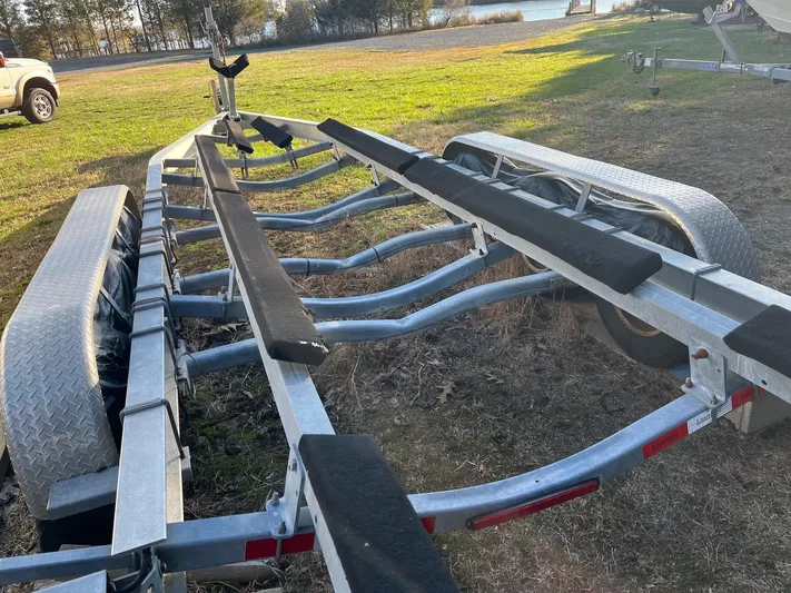 Salty Rim Yacht Photos Pics Boat trailer for 2015 Sea Hunt Gamefish 30, parked on grass near water.