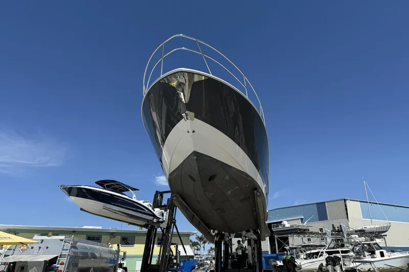  Yacht Photos Pics 2023 Regal 36 XO yacht on lift under clear blue sky.