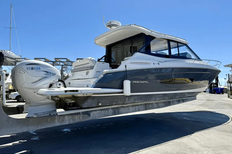  Yacht Photos Pics 2023 Regal 36 XO boat with Yamaha engine, displayed on a lift under clear blue sky.