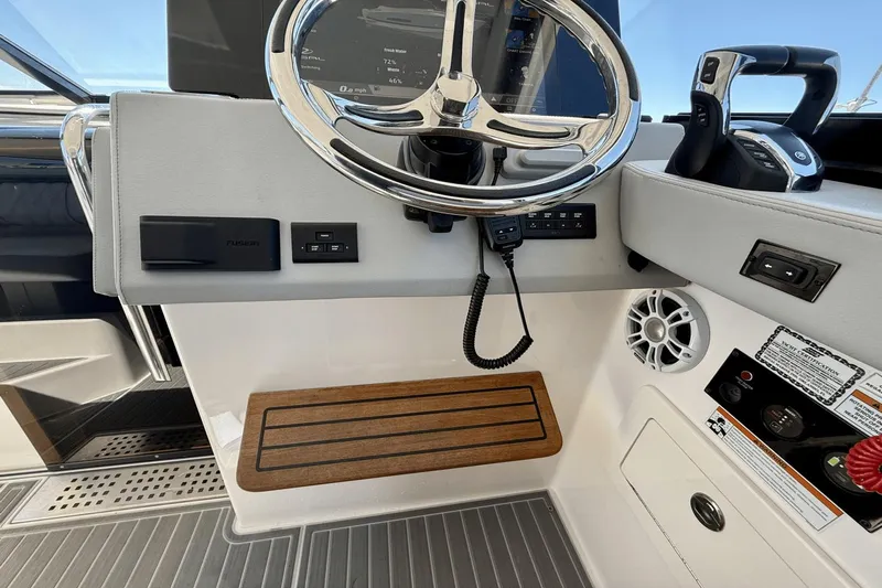  Yacht Photos Pics 2023 Regal 36 XO helm with steering wheel, controls, and wood footrest.