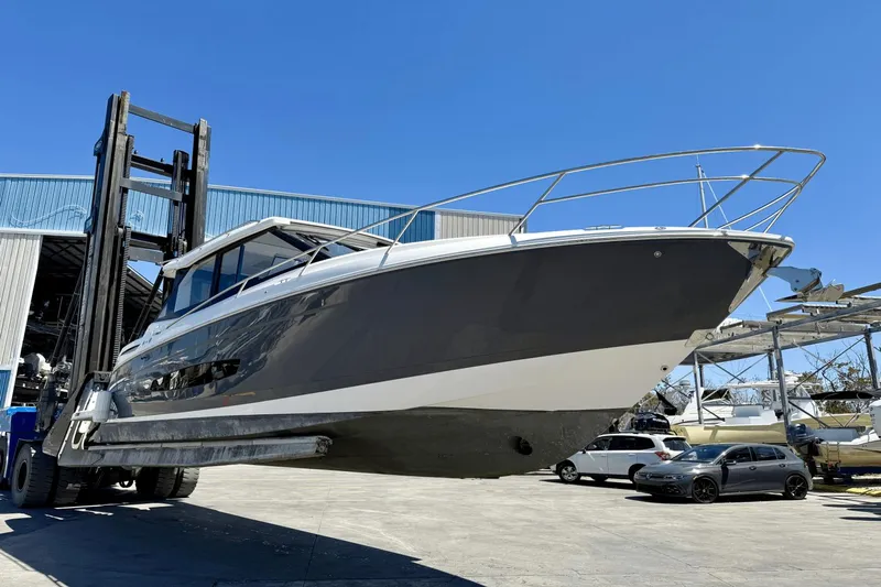  Yacht Photos Pics 2023 Regal 36 XO boat lifted by forklift in marina setting.