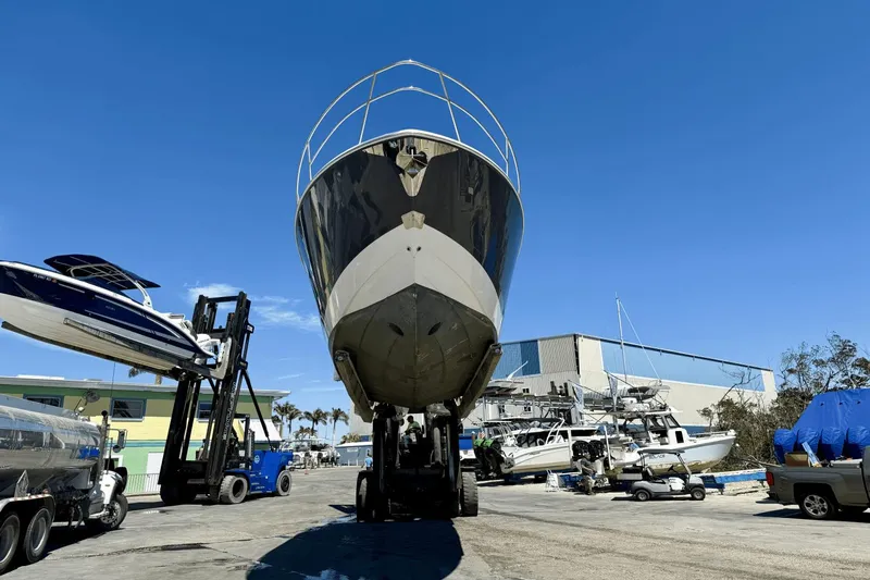  Yacht Photos Pics 2023 Regal 36 XO boat lifted in marina, clear blue sky background.
