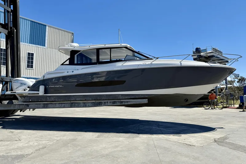  Yacht Photos Pics 2023 Regal 36 XO boat lifted at marina, clear sky background.