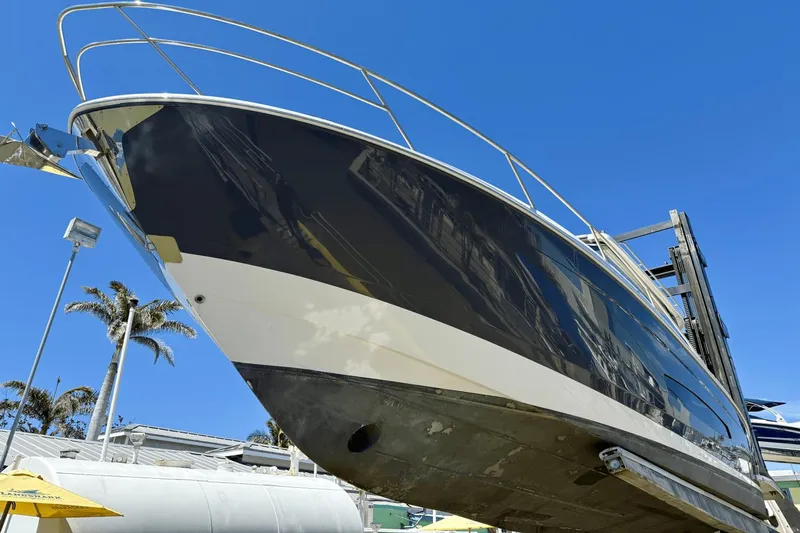  Yacht Photos Pics 2023 Regal 36 XO yacht on lift, blue sky background, palm trees visible.